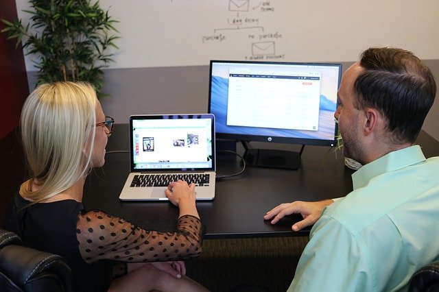 Two people going over an SEO project on a laptop