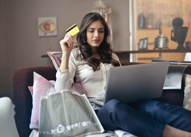Women holding card while doing online shopping