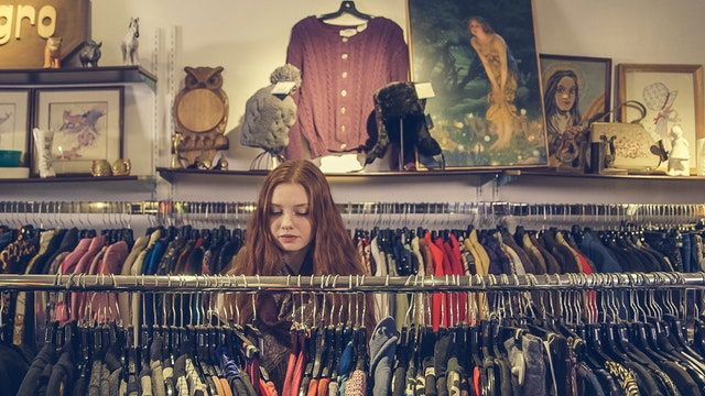 A woman looking at the clothes in a fashion store