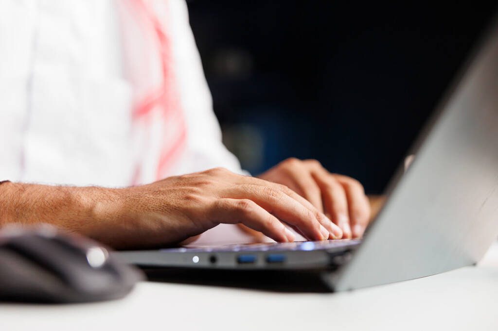 person typing on a laptop for on page optimization