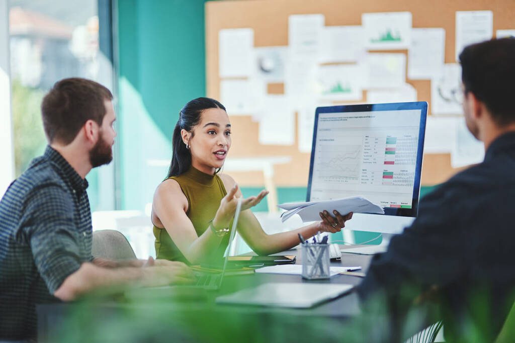 group of people in front of a desktop with charts