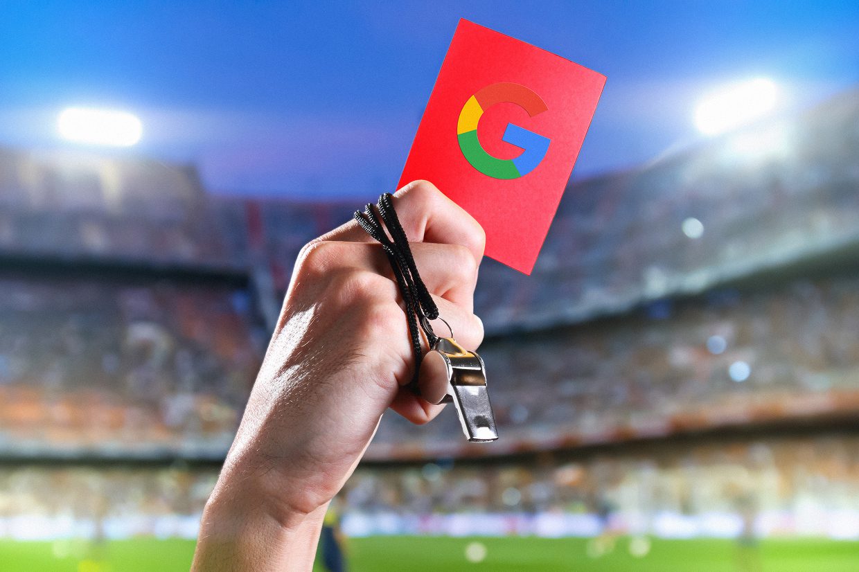 Hand with whistle holding red card with Google logo