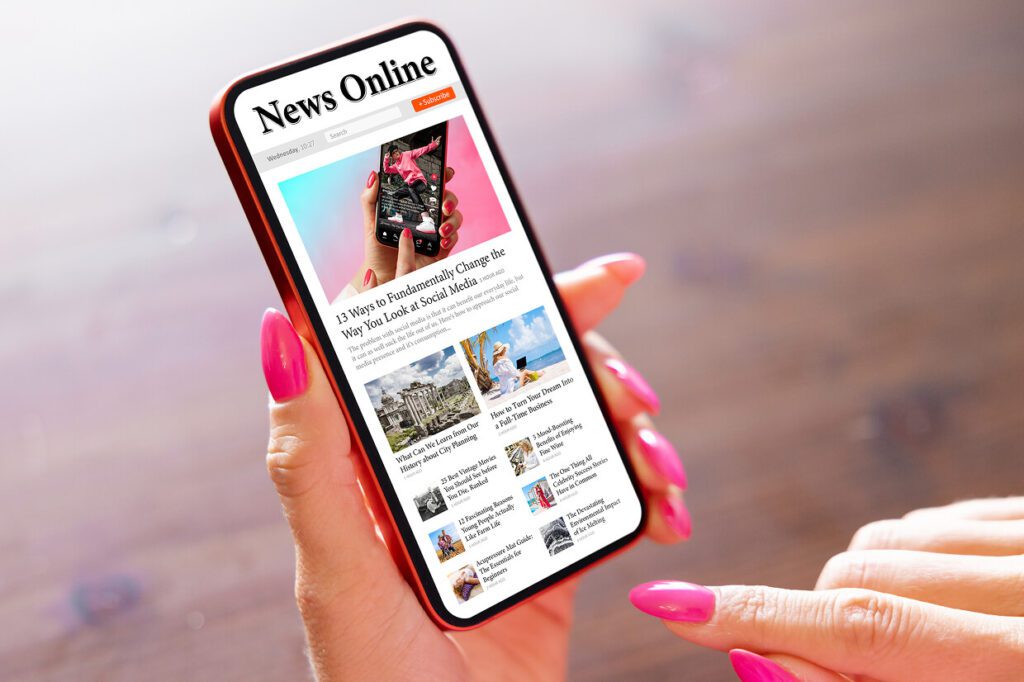Hand holding a mobile device with News Online on screen