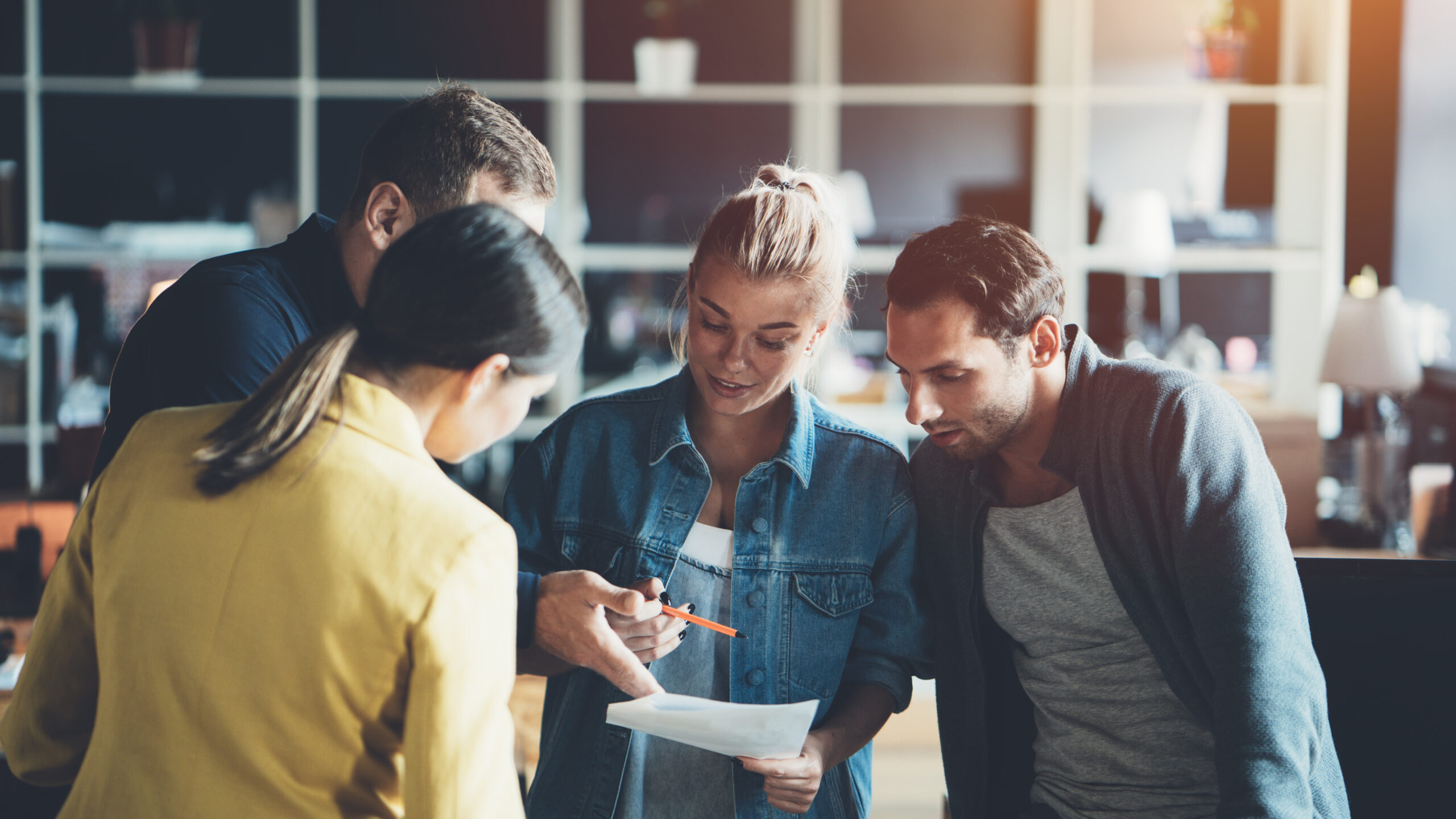 Team meeting of four people discussing new monthly work plan