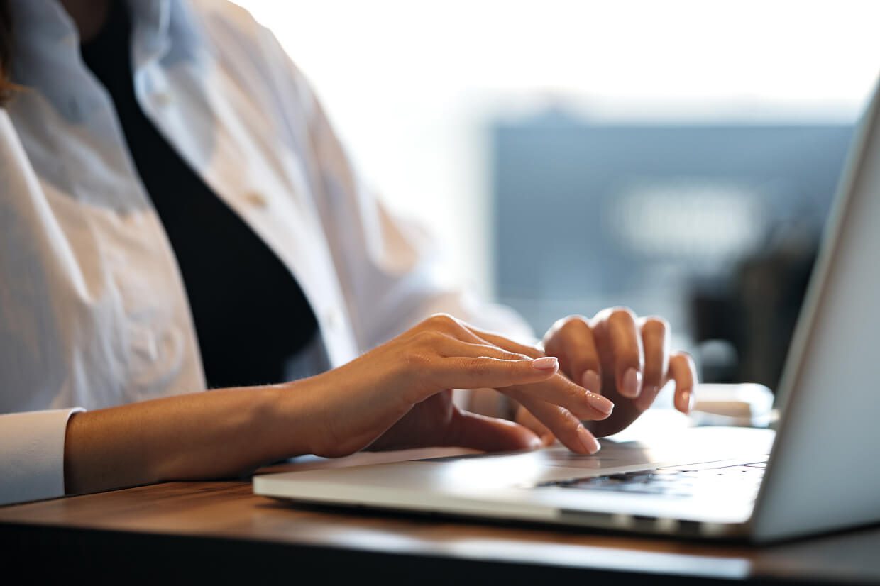 Hands typing on a laptop