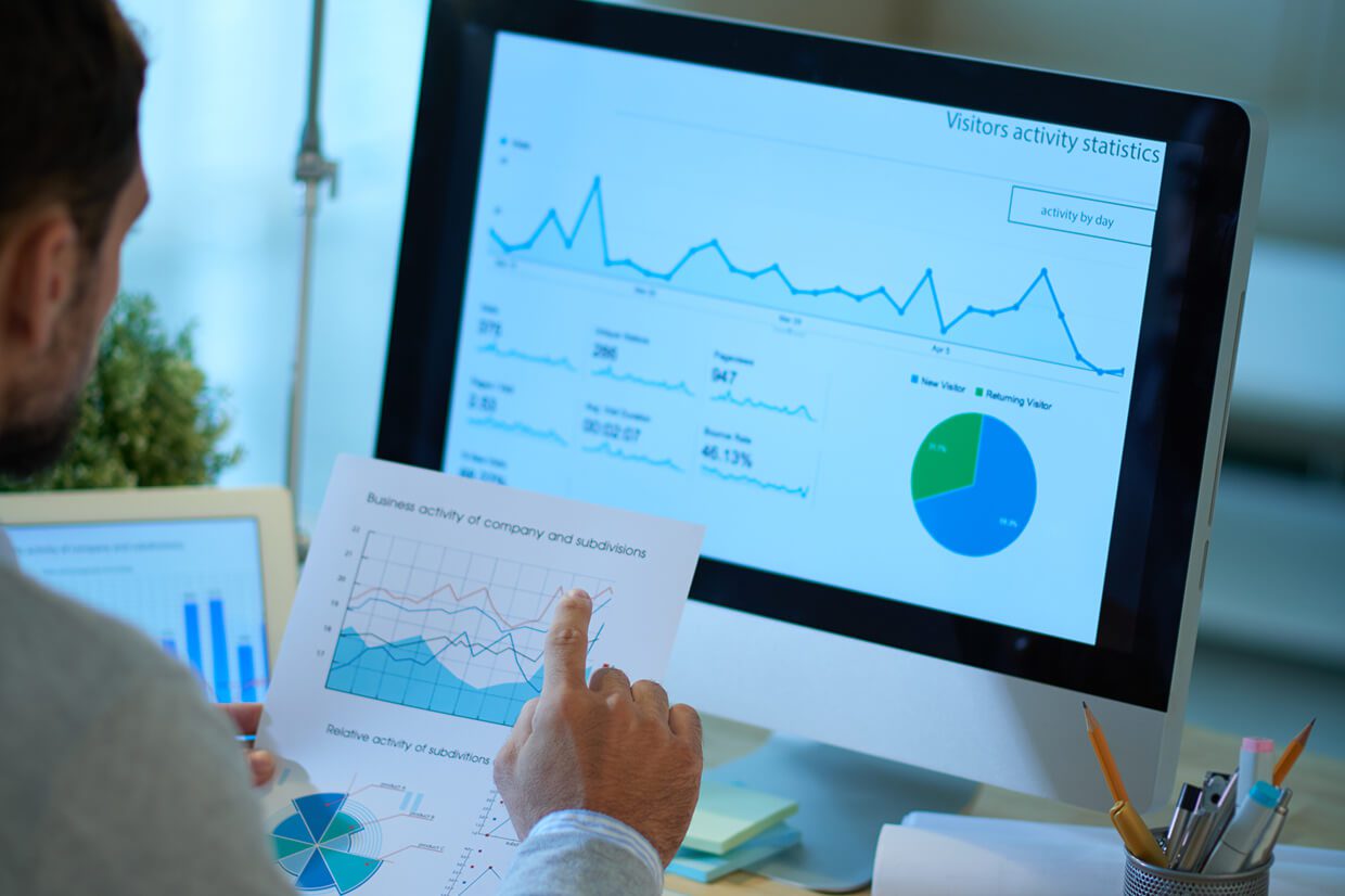 Desktop and laptop monitors with charts, and chart on printed paper