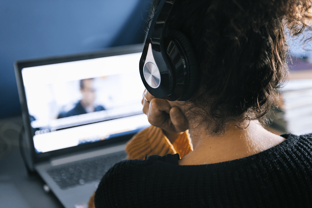 Woman with headphones watching a computer screen